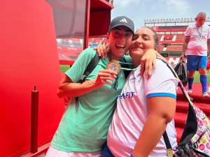 Entrenadora y jugadora del Club de fúbol celebran la victoria